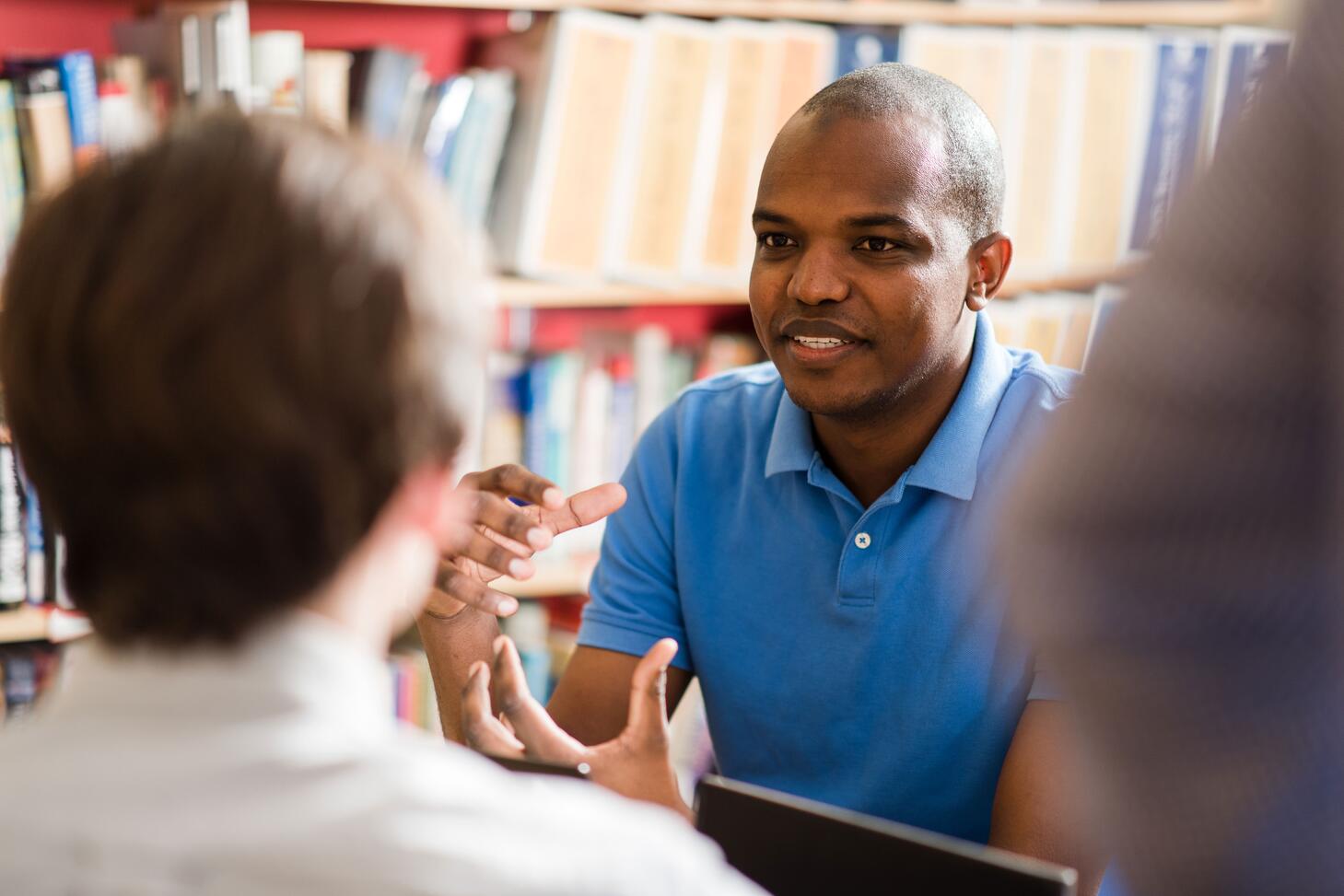 A group of students discuss a problem during class