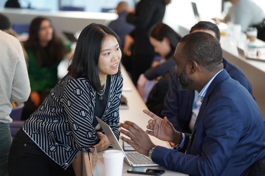 Two students discussing a topic in class.