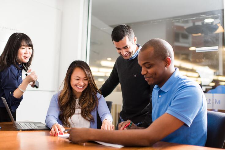 A diverse group of students work together on a group project