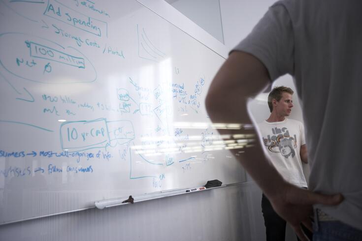 Students solving a problem on a whiteboard